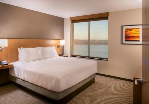 a hotel room with a large bed and a window at Hyatt Place East Moline/Quad Cities in East Moline