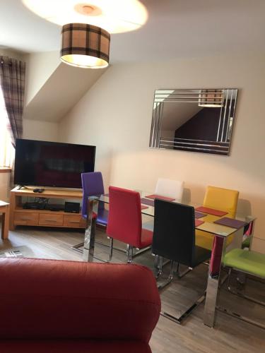 a living room with a table and colorful chairs at Cairngorm Mountain View in Aviemore