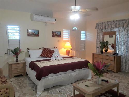 um quarto com uma cama grande e uma mesa em Paradise Inn em Port Antonio