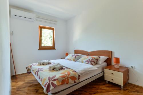 a bedroom with a bed with two stuffed animals on it at Lumbre Apartment in Vabriga