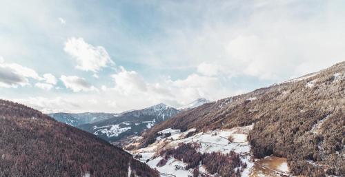 a view of a mountain range with snow and trees at Boutique Hotel Kircher in Sarntal