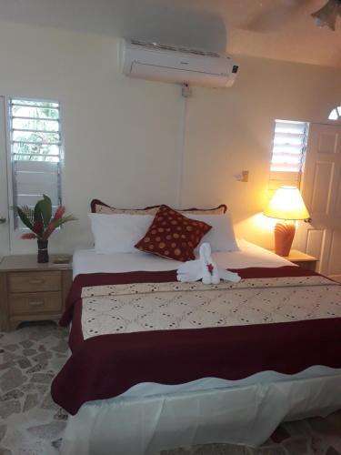 a bedroom with a bed with a stuffed animal on it at Paradise Inn in Port Antonio