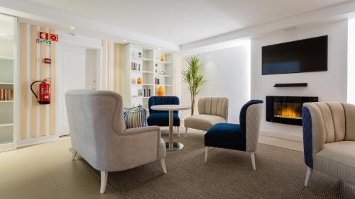 a living room with chairs and a fireplace at Quinta do Lago Country Club in Quinta do Lago