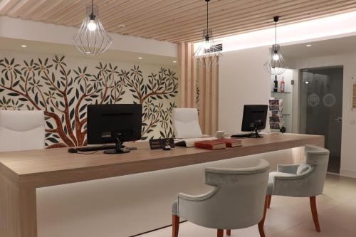 a reception desk with two chairs and a television at Quinta do Lago Country Club in Quinta do Lago