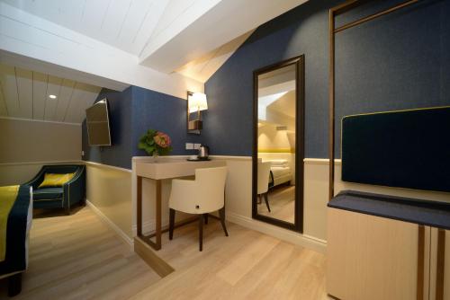 a room with a desk and a mirror and a bed at Hotel Canon d'Oro in Conegliano