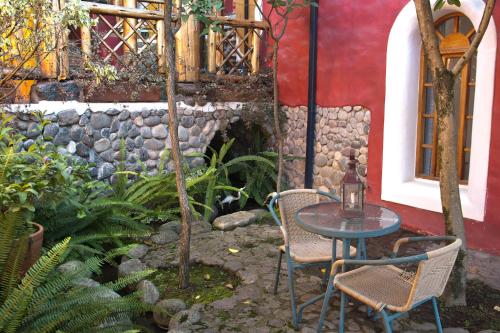 a table and two chairs sitting in a garden at INTIYAYA - Boutique Lodge in Otavalo