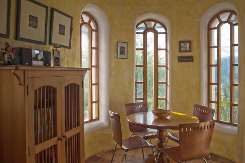 a dining room with a table and chairs and windows at INTIYAYA - Boutique Lodge in Otavalo