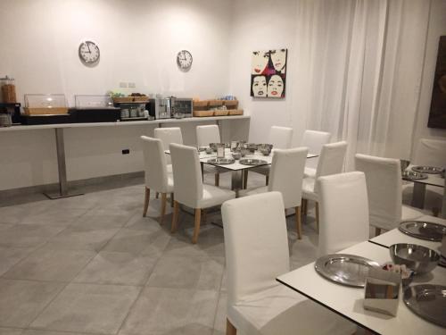 una sala da pranzo con tavolo e sedie bianche di Da Battista a Suzzara
