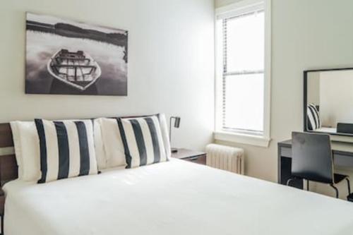 a bedroom with a white bed and a desk with a computer at Convenient & Newly Decorated 1BR Apartment - Roscoe 1D in Chicago