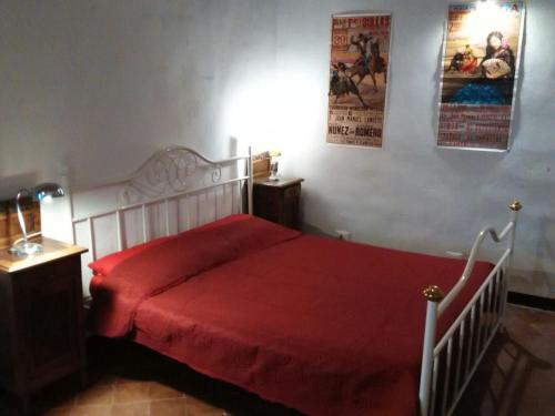 1 dormitorio con cama blanca y manta roja en Lovely renovated apartment near Dolcedo, en Dolcedo
