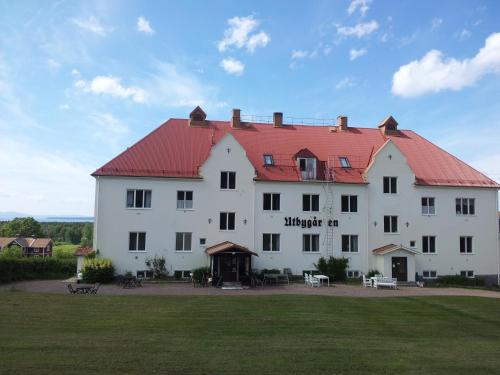 um grande edifício branco com um telhado vermelho em Utbygårdens Hostel em Rättvik