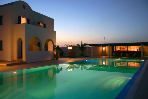 a villa with a swimming pool in front of a house at Blue Bay Villas in Kamari