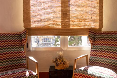 two chairs in front of a window with a window shade at Casa Rosalía in Ibi
