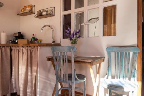 a kitchen with two blue chairs and a wooden table at Casa Rosalía in Ibi