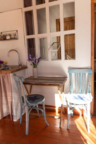 a kitchen with a wooden table and two chairs at Casa Rosalía in Ibi