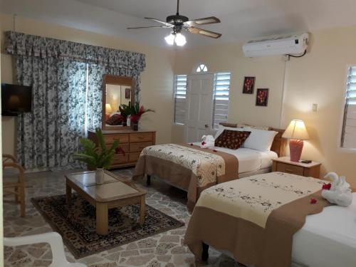 a bedroom with two beds and a living room at Paradise Inn in Port Antonio