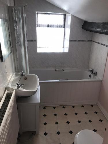 a bathroom with a tub and a sink and a toilet at The Cottage, cosy 2 bedroom pet friendly perfect for contractors free secure parking,CCTV in Leeds