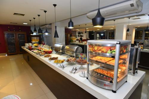 una línea de buffet en un restaurante con muchas comidas diferentes en Panorama Tower Hotel, en Ipatinga