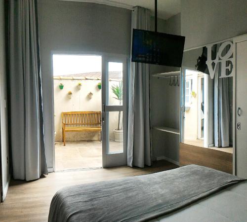 Un dormitorio con una cama y vista a un patio. en Solar Di Petrópolis - Apartamentos de Temporada, en Nova Petrópolis