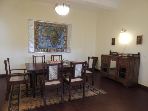 a dining room with a table and chairs and a map on the wall at Hotel Villa Malindi in Malindi