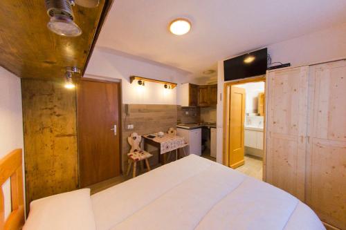 um quarto com uma grande cama branca e uma cozinha em CasaMau Studio em Campitello