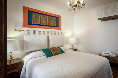 a bedroom with a white bed and a chandelier at Hotel Tapalpa de Mis Amores in Tapalpa