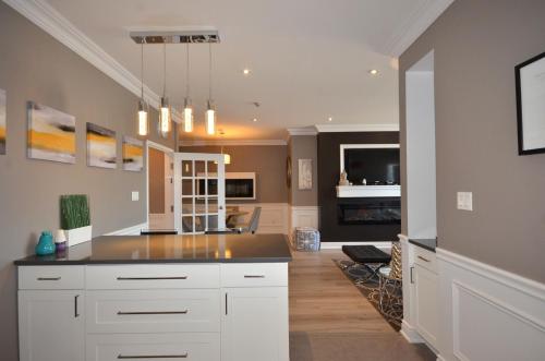 a kitchen with white cabinets and a black counter top at The SoMa Furnished Residences in Hamilton