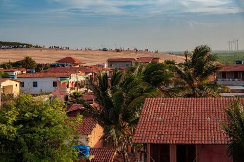 a town with houses and palm trees and a field at Hotel Alta Vista in Canoa Quebrada