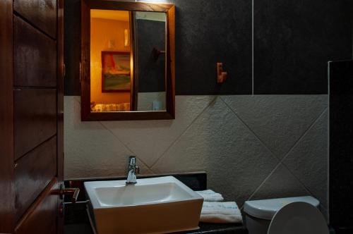 a bathroom with a sink and a toilet and a mirror at Hotel Alta Vista in Canoa Quebrada