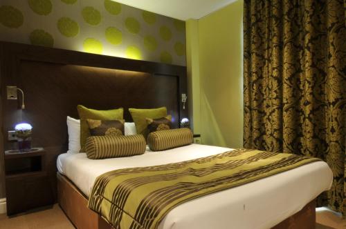 1 dormitorio con 1 cama grande y paredes verdes en The Golf Hotel Woodhall Spa, en Woodhall Spa