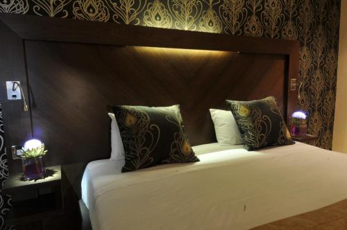 a bedroom with a large white bed with a wooden headboard at The Golf Hotel Woodhall Spa in Woodhall Spa