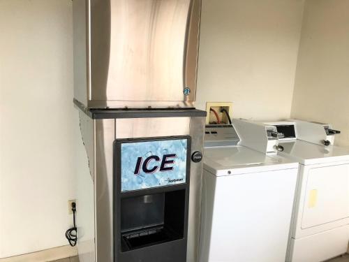 TV en una cocina con máquina de hielo en American Inn & Suites, en Albuquerque