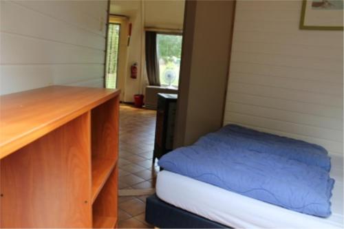 um quarto com uma cama e uma secretária de madeira em Iglo Bungalow 36 em Chaam