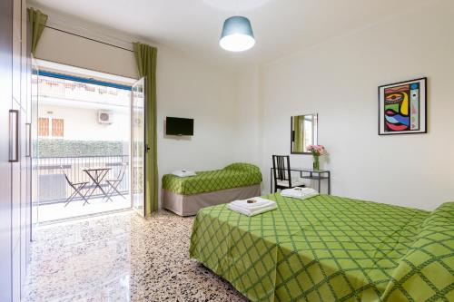 a bedroom with a green bed and a balcony at B&B La Primula in Pompei