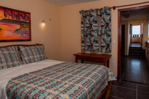 a bedroom with a bed and a table and a window at Hotel Alta Vista in Canoa Quebrada