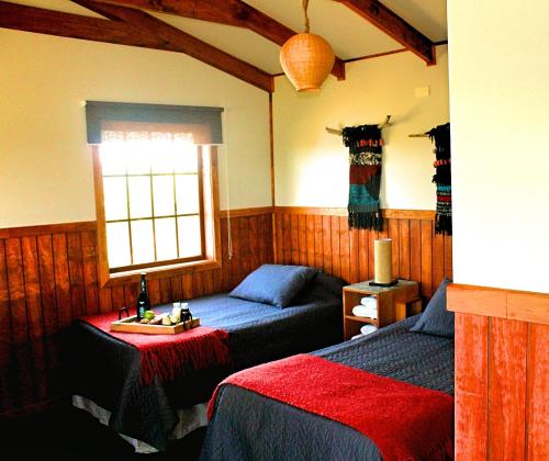 a bedroom with two beds and a window at Dorotea Vista in Puerto Natales