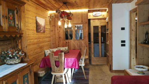a dining room with a table in a wooden cabin at Daniela Apartment in Cortina dʼAmpezzo