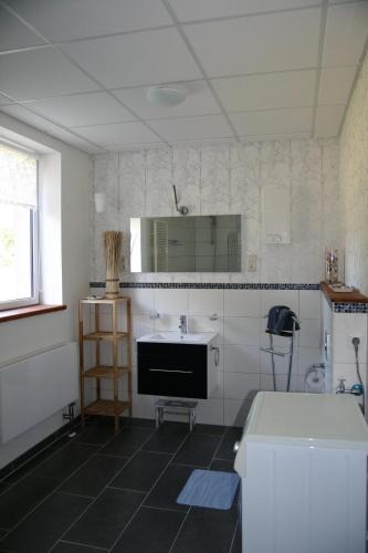 a white kitchen with a sink and a mirror at FeWo Vahls Mika in Elmenhorst