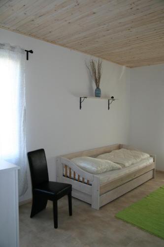 a bedroom with a bed and a chair in a room at FeWo Vahls Mika in Elmenhorst