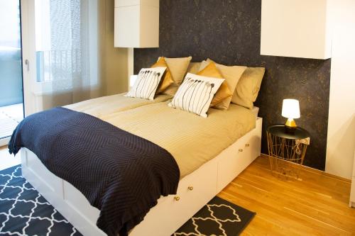 een slaapkamer met een groot bed met kussens erop bij Cozy & Cool Apartment * 5 Min to City Center in Wenen