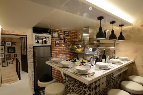 - une cuisine avec comptoir et vaisselle dans l'établissement Loft Basfour-Paris Centre tout équipé avec SAUNA!-Paris 4e, à Paris
