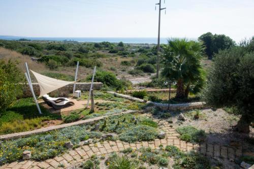 a garden with a hammock and some plants at Le Gioie - Villa Macchia Mediterranea - Splendida villa vista mare immersa nel verde in Torre Pali 