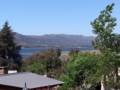 a view of a lake and a house with trees at Los Horneros in Potrero de Garay