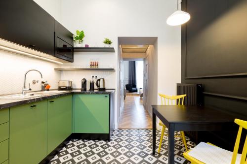 a kitchen with green cabinets and a dining table at The Oktogon Executive Apartment in Budapest