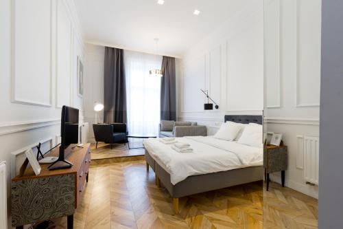 a bedroom with a bed and a living room at The Oktogon Executive Apartment in Budapest