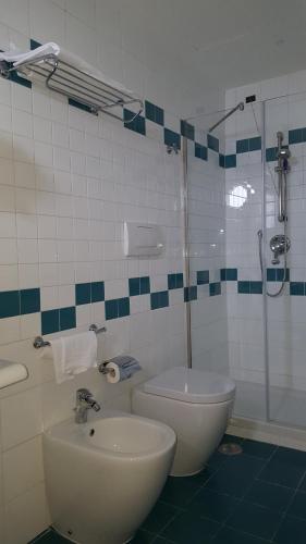 a bathroom with a shower and a toilet and a sink at Grand Hotel Moon Valley in Vico Equense