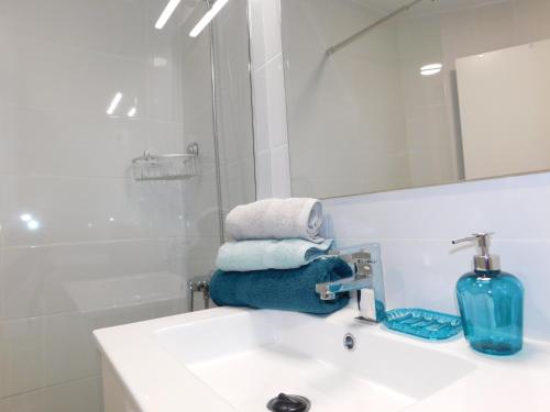 a bathroom with a sink and a mirror and towels at LOLALAND in Morro del Jable