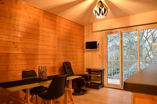 una sala da pranzo con pareti in legno, tavolo e sedie di F1 entier Cosy style CHALET Montgeron, Proche Paris a Montgeron