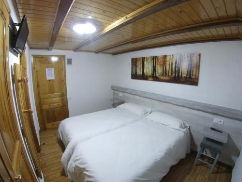 1 dormitorio con 2 camas, mesa y puerta en Hostal Casa Palmira, en Espot