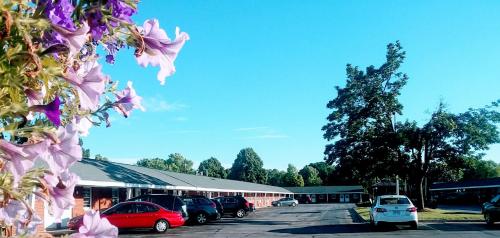 a parking lot with cars parked in front of a building at Bay Motel in Green Bay